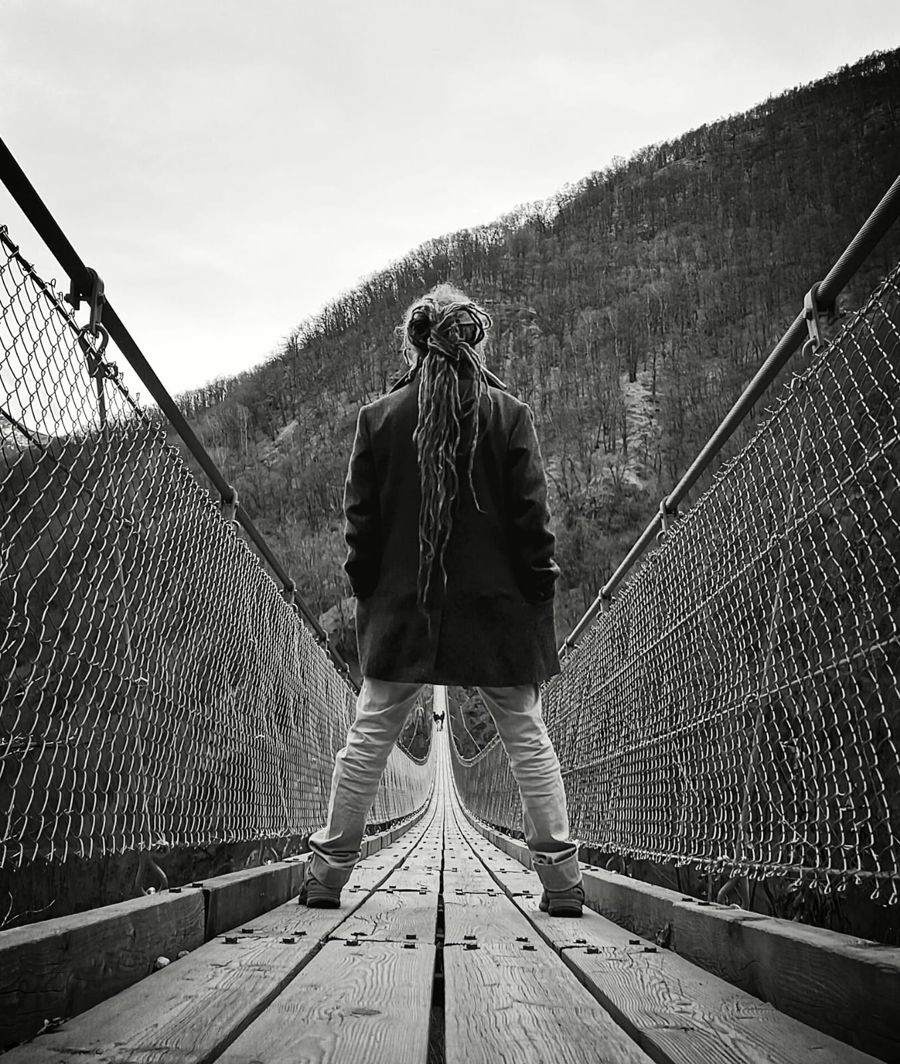 Markus Egloff seen from behind on a suspension bridge in Ticino